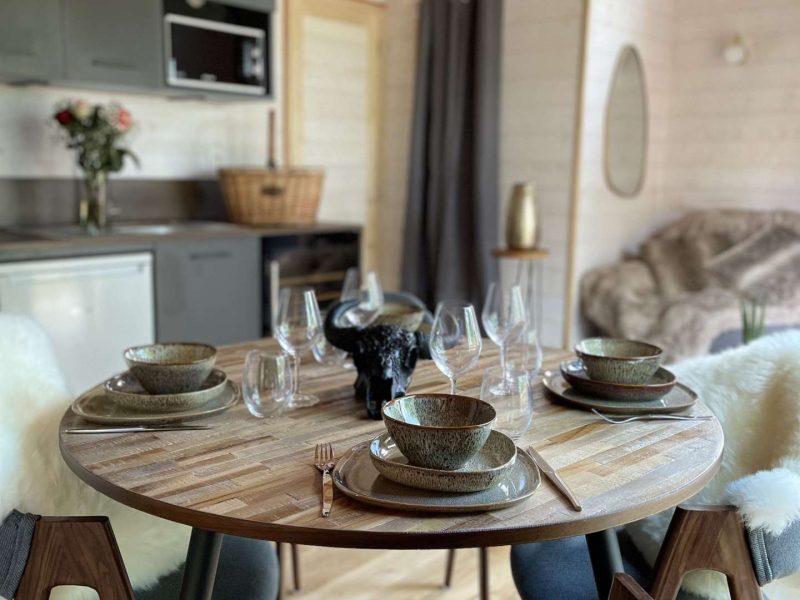 Chalet moderne avec une table élégante, décorée pour un repas convivial.