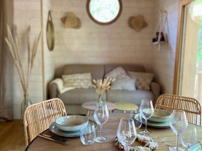 Cabane en bois en Auvergne, intérieur lumineux avec table élégamment dressée.