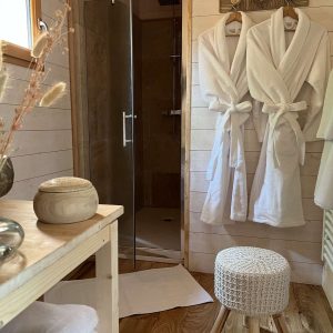 Hébergement insolite en Auvergne : intérieur chaleureux avec douche et peignoirs confortables.