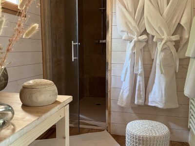 Hébergement insolite en Auvergne : intérieur chaleureux avec douche et peignoirs confortables.