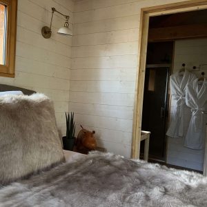 Chalet en bois douillet en Auvergne, avec literie en fourrure et salle de bain moderne.