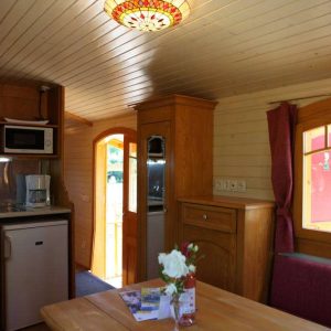 Intérieur chaleureux dun chalet en bois, avec cuisine équipée et lumière tamisée.