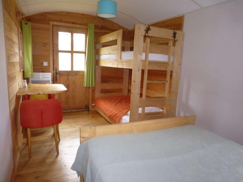 Chalet en bois avec lits superposés et décoration chaleureuse. Ambiance conviviale.