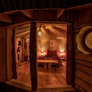 Hébergement insolite en yourte, intérieur chaleureux avec éclairage tamisé.