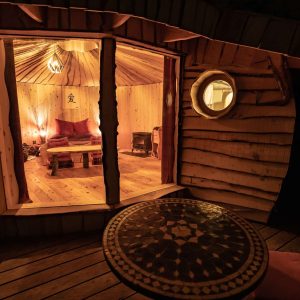 Hébergement insolite en forme de cabane, intérieur chaleureux avec table décorative.