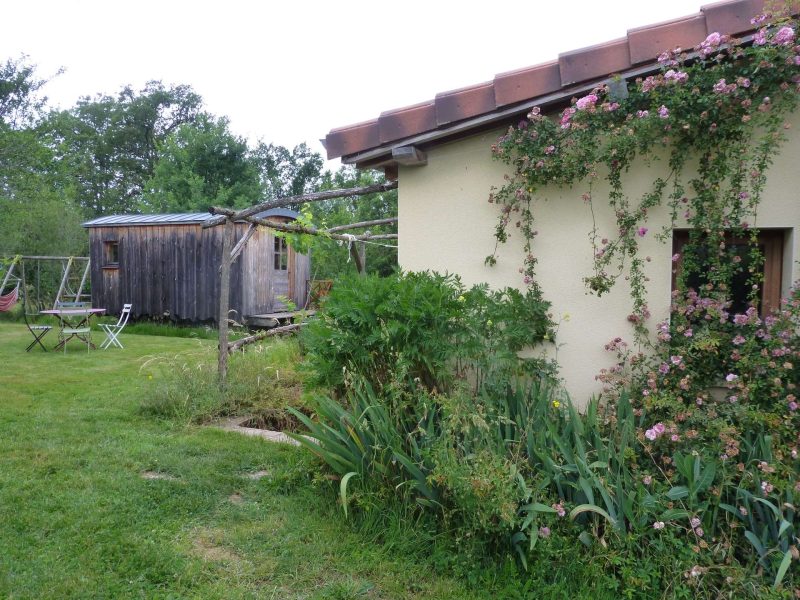 Charmante maison avec jardin fleuri et un cabanon en bois à larrière.