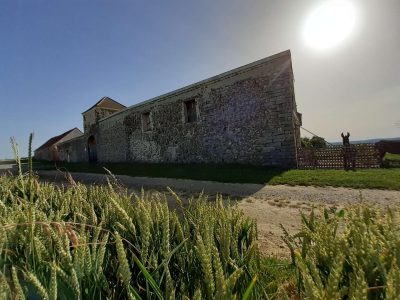Hébergement insolite en pierre dans les Hauts-de-France, entouré de champs verdoyants.