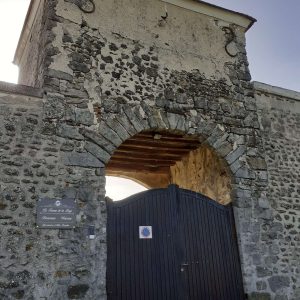 Ancien bâtiment en pierre avec une grande porte en bois, hébergement insolite à Hauts-de-France.
