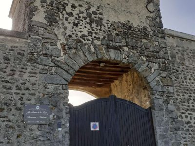 Ancien bâtiment en pierre avec une grande porte en bois, hébergement insolite à Hauts-de-France.