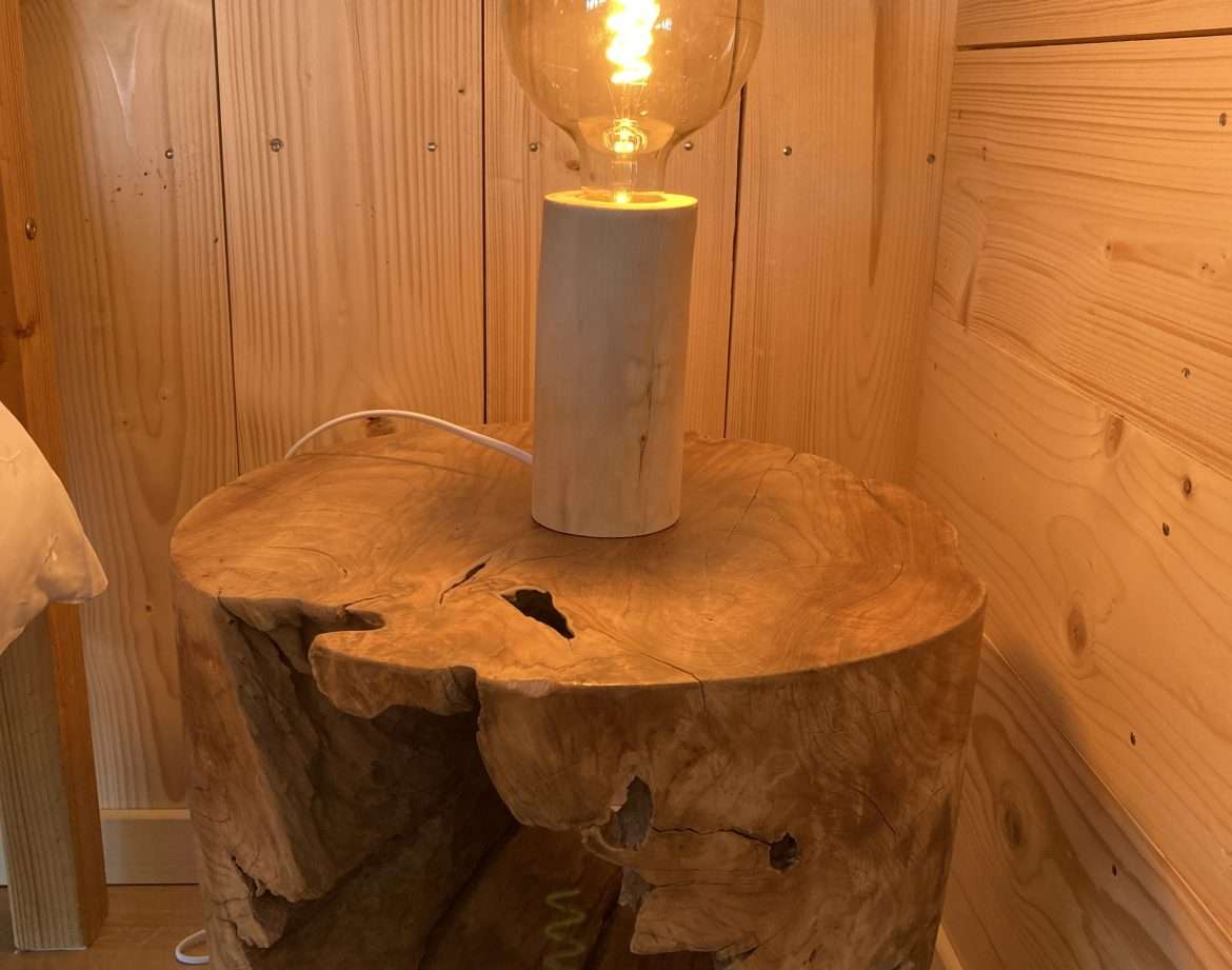 Hébergement insolite en bois dans le Languedoc-Roussillon, avec lampe design sur table.