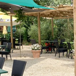 Espace extérieur dun hébergement insolite avec tables et parasols colorés.