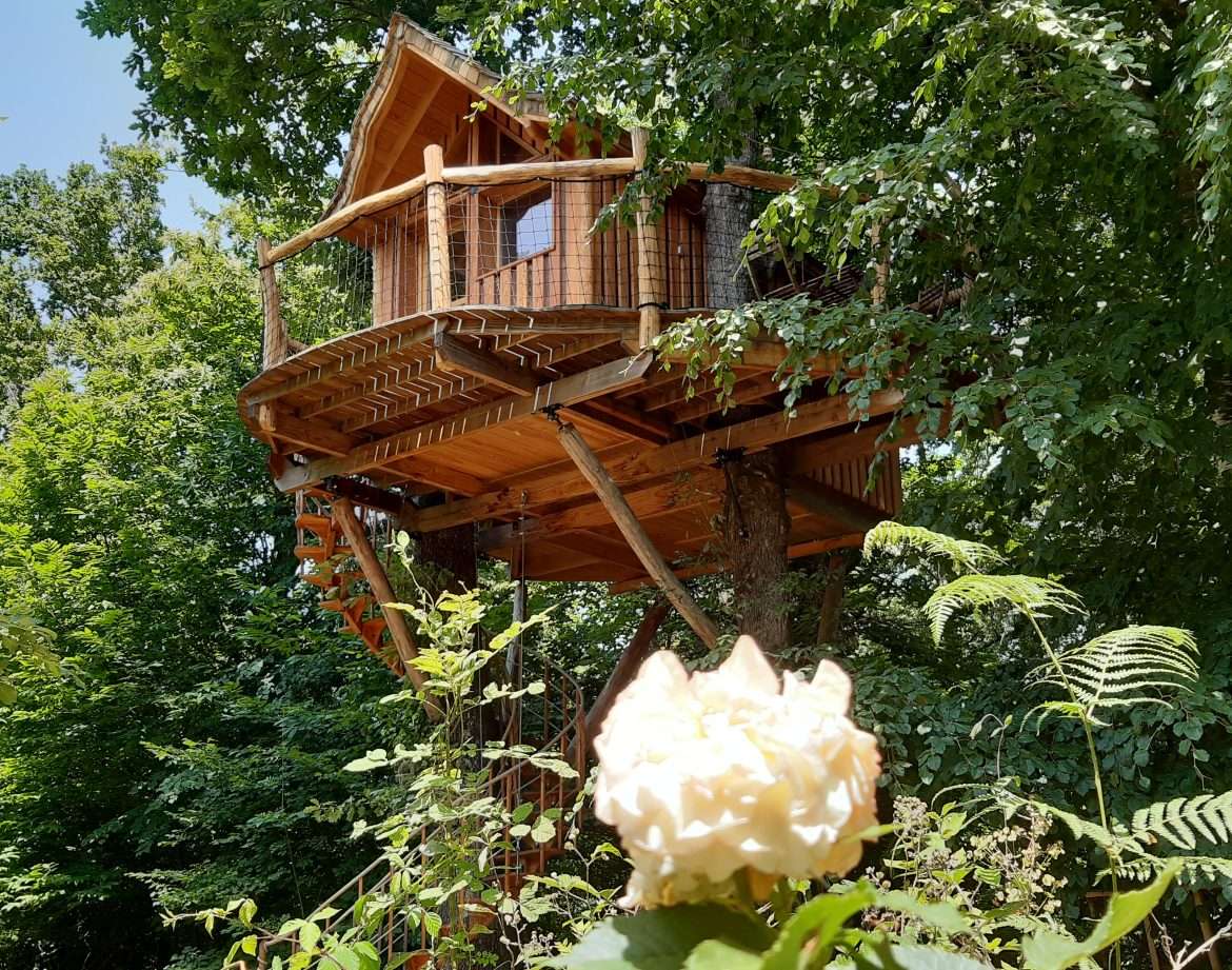 Cabane dans les arbres en Aquitaine, perchée parmi les feuillages verdoyants.