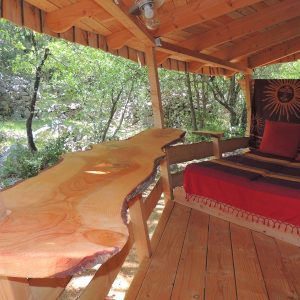 Cabane en bois dans la nature, avec un lit confortable et une table en bois massif.