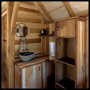 Hébergement insolite en Aquitaine : intérieur en bois chaleureux avec lavabo en pierre.