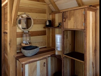 Hébergement insolite en Aquitaine : intérieur en bois chaleureux avec lavabo en pierre.