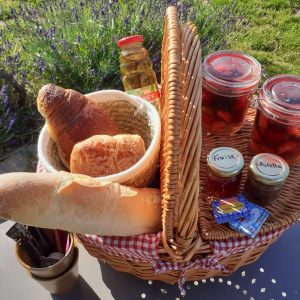 Panier pique-nique avec pains, confitures et fruits, idéal pour un séjour insolite en