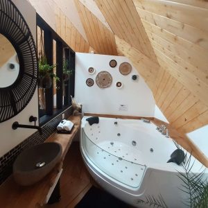 Hébergement insolite en Hauts-de-France avec jacuzzi et décoration en bois chaleureux.
