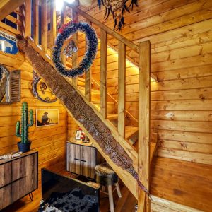 Cabane en bois chaleureuse avec un escalier en bois et des décorations vintage.