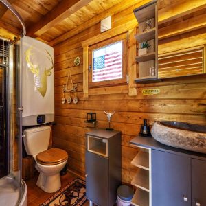 Cabane en bois avec salle de bain moderne et décor chaleureux en Auvergne-Rhône-Alpes.