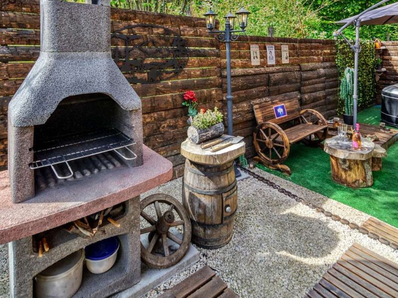 Hébergement en chalet avec barbecue en pierre et espace détente extérieur.