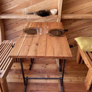 Hébergement insolite en bois en Provence-Alpes-Côte dAzur, avec table et bancs modernes.