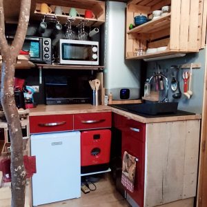 Cottage en bois à Grand-Est avec cuisine colorée et éléments en bois naturel.