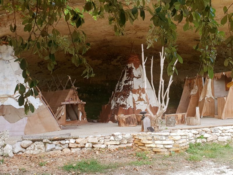 Tipis en pleine nature, abrités sous une roche, offrant un cadre unique et chaleureux.