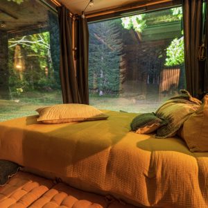 Hébergement insolite en Auvergne-Rhône-Alpes, lit confortable avec vue sur la nature.