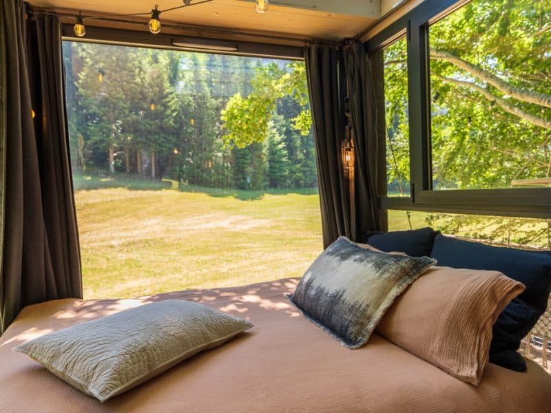 Cabane cosy avec vue panoramique sur la nature et un plafond vitré.