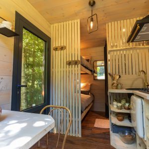 Cabane en bois cosy en Auvergne, avec cuisine et lits superposés. Ambiance chaleureuse.
