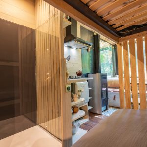 Cabane moderne en bois avec douche et kitchenette, au cœur de la nature.