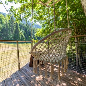 Hébergement insolite en cabane perchée, avec un fauteuil suspendu au cœur de la nature.