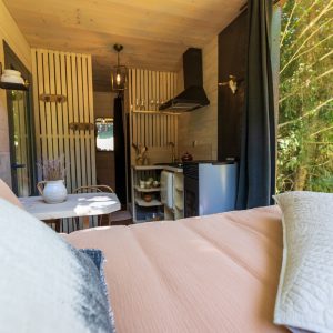 Hébergement insolite en bois en Auvergne-Rhône-Alpes, avec vue sur la nature verdoyante.