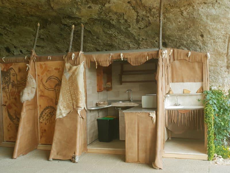 Hébergement insolite en grotte avec cuisine rustique et décor en cuir.