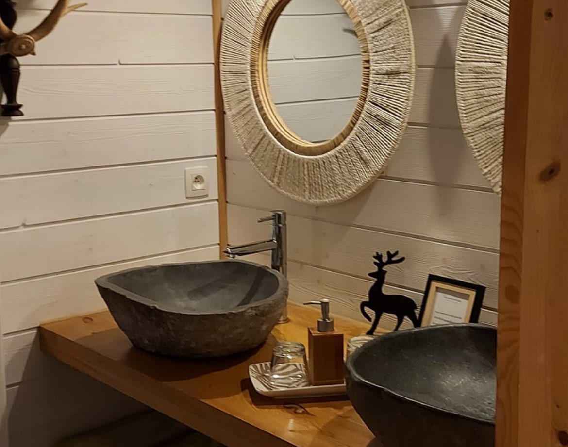 Salle de bain dun hébergement insolite en Aquitaine, avec deux lavabos en pierre.