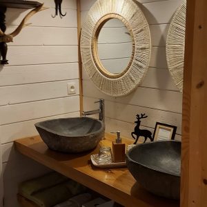 Salle de bain dun hébergement insolite en Aquitaine, avec deux lavabos en pierre.