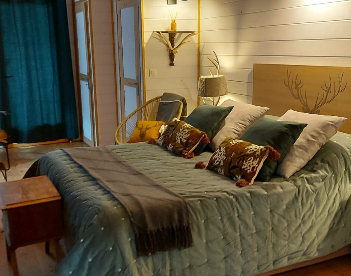 Chambre cosy dans un hébergement insolite en Aquitaine, décorée avec goût et lumière douce.