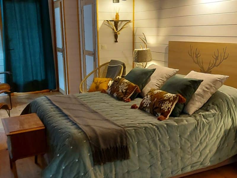 Chambre cosy dans un hébergement insolite en Aquitaine, décorée avec goût et lumière douce.