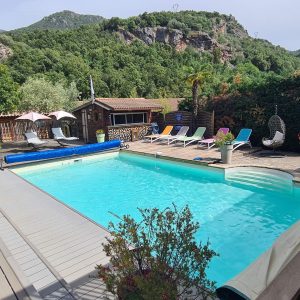 Hébergement insolite en Corse avec piscine et transats au milieu de la nature verdoyante.