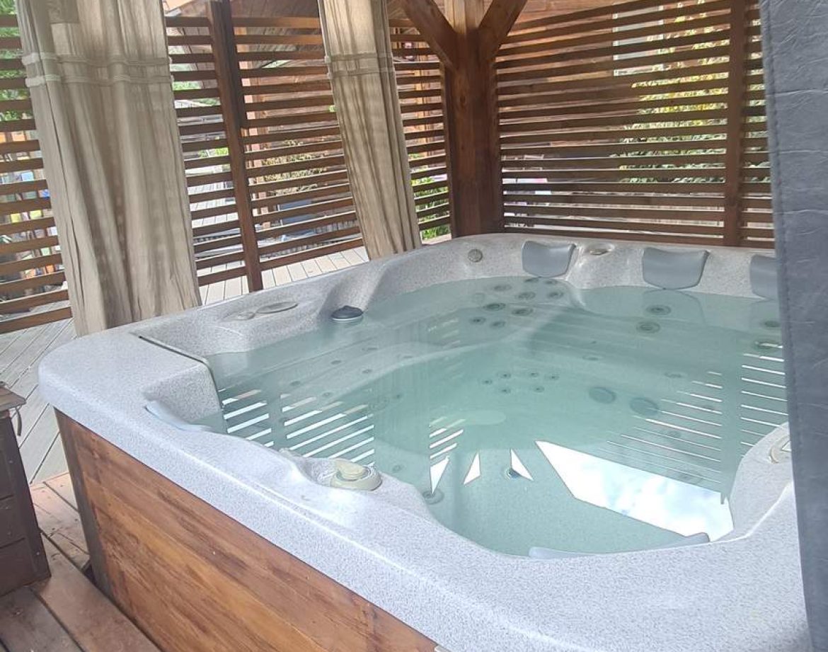 Hébergement insolite en Corse avec jacuzzi privé sous un abri en bois.