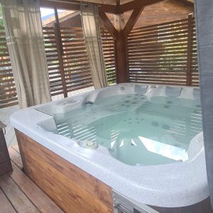 Hébergement insolite en Corse avec jacuzzi privé sous un abri en bois.