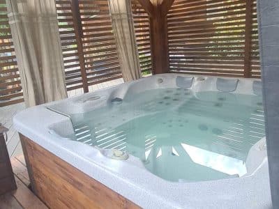 Hébergement insolite en Corse avec jacuzzi privé sous un abri en bois.