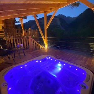 Cabane perchée en Provence-Alpes-Côte dAzur avec jacuzzi lumineux et vue montagne.