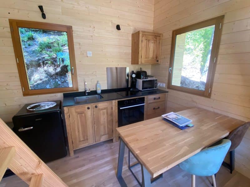 Chalet en bois avec cuisine équipée et vue sur la nature. Ambiance chaleureuse et cosy.