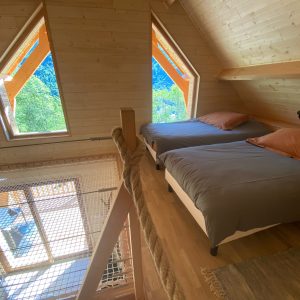 Chalet en bois avec vue panoramique et fenêtres en triangle, idéal pour un séjour unique.