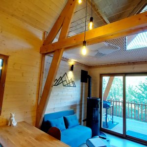 Cabane en bois moderne avec grandes fenêtres et vue sur la nature.