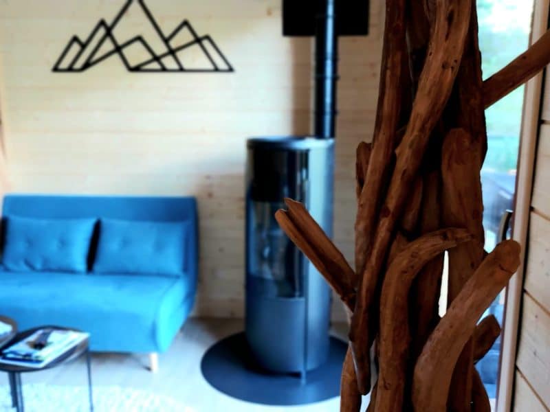 Chalet moderne avec un salon cosy, poêle à bois et décor en bois naturel.