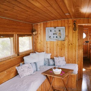 Toue en bois au bord de la Loire, intérieur chaleureux avec canapés confortables.