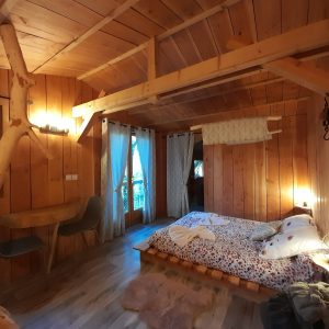 Chalet en bois chaleureux avec lit douillet et vue sur la forêt en Auvergne-Rhône-Alpes.