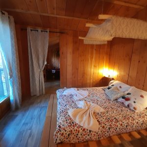 Chalet en bois chaleureux avec lit douillet et vue sur la nature en Auvergne-Rhône-Alpes.
